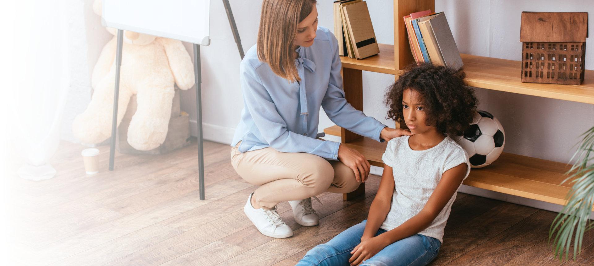 A caregiver comforting a child in a bright living space