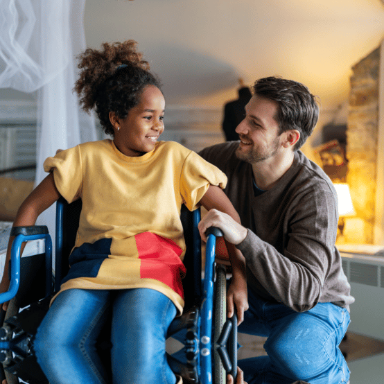 A caregiver and a young person sharing a smile at home